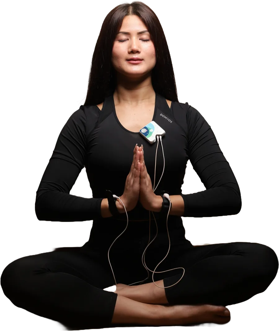 A woman meditating while Healy delivers a program through wrist electrodes